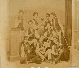 Gibraltar, retrato de un grupo de nueve hombres jóvenes, algunos con instrumentos musicales o copas, en actitud festiva. Alexander Cavilla.