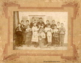 España, retrato de un maestro y sus alumnos en el interior de un aula. Autor desconocido.