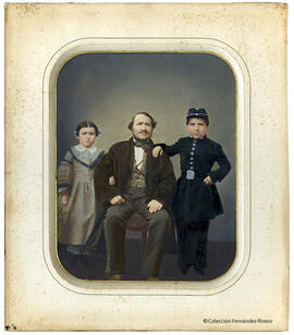 Retrato de un hombre sentado junto a una niña y un niño vestido de uniforme, quizás sus hijos. Fotógrafo desconocido.