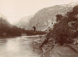 Malaga, hombre cruzando el río Guadalhorce mediante una tirolina. Miguel Osuna.