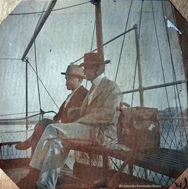 Tarifa (Cádiz), dos viajeros a bordo de una embarcación frente a la ciudad. Fotógrafo desconocido.